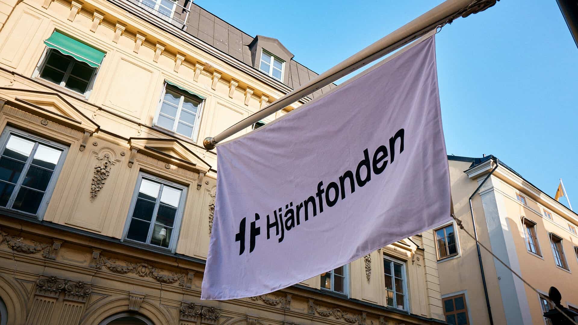 Foto på Hjärnfondens flagga som hänger utanför huvudkontoret i Gamla stan, Stockholm.