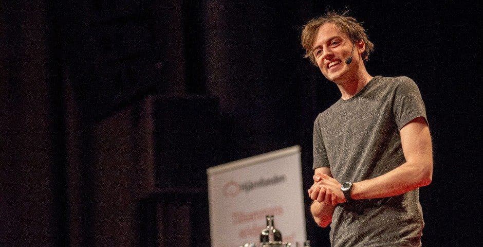 Jonas von Essen står på scen och talar i en mikrofon.