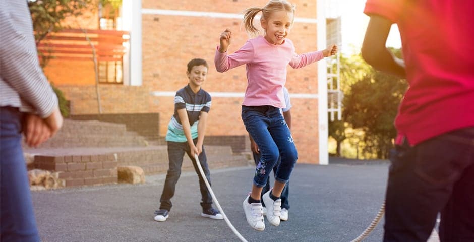 Skolbarn hoppar rep på skolgården