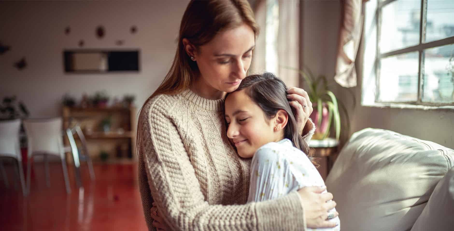 Mamma håller om sin dotter