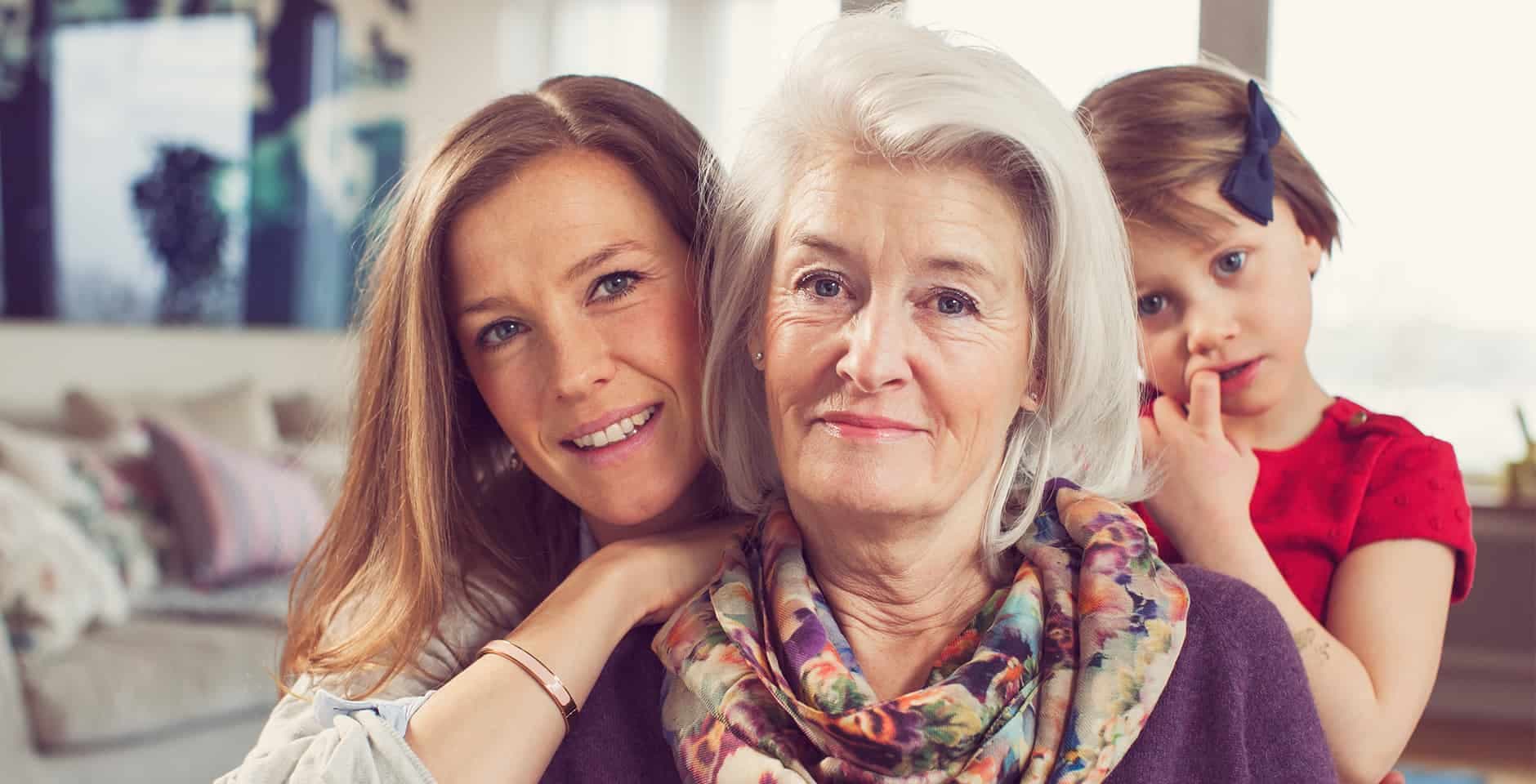 Mormor sitter med sin dotter och barnbarn.