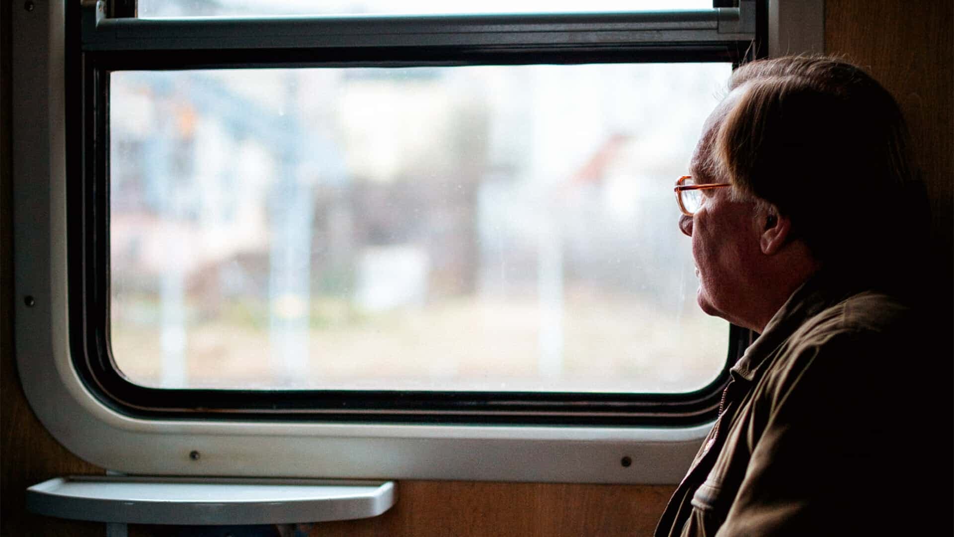 Äldre person som tittar ut igenom tunnelbanefönster
