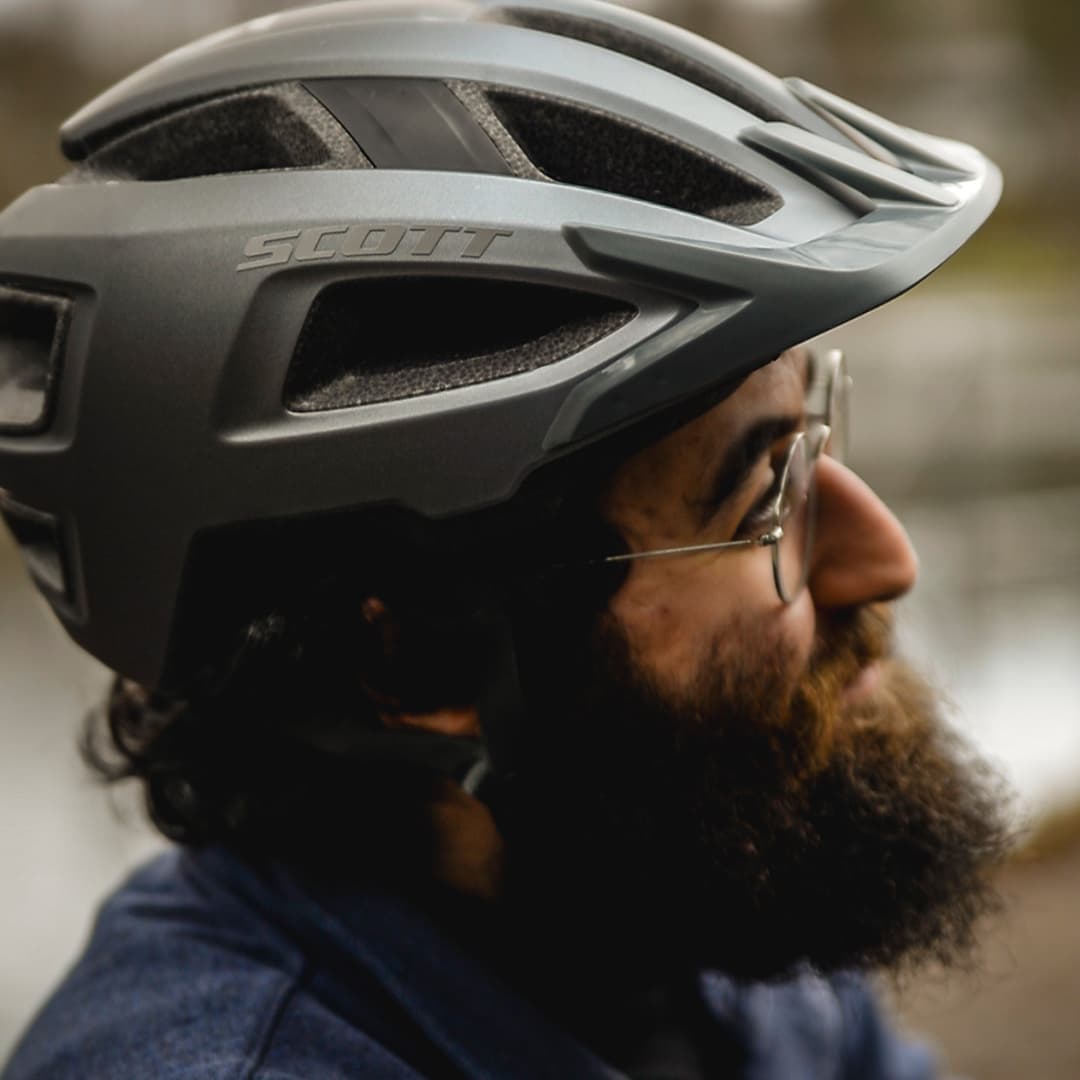 En närbild på en man med skägg som bär en mörk cykelhjälm
