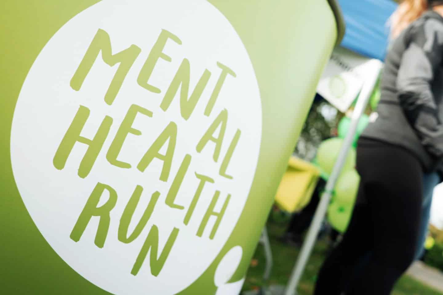 Bild på ett bord med Mental health runs logga med personer i bakgrunden.