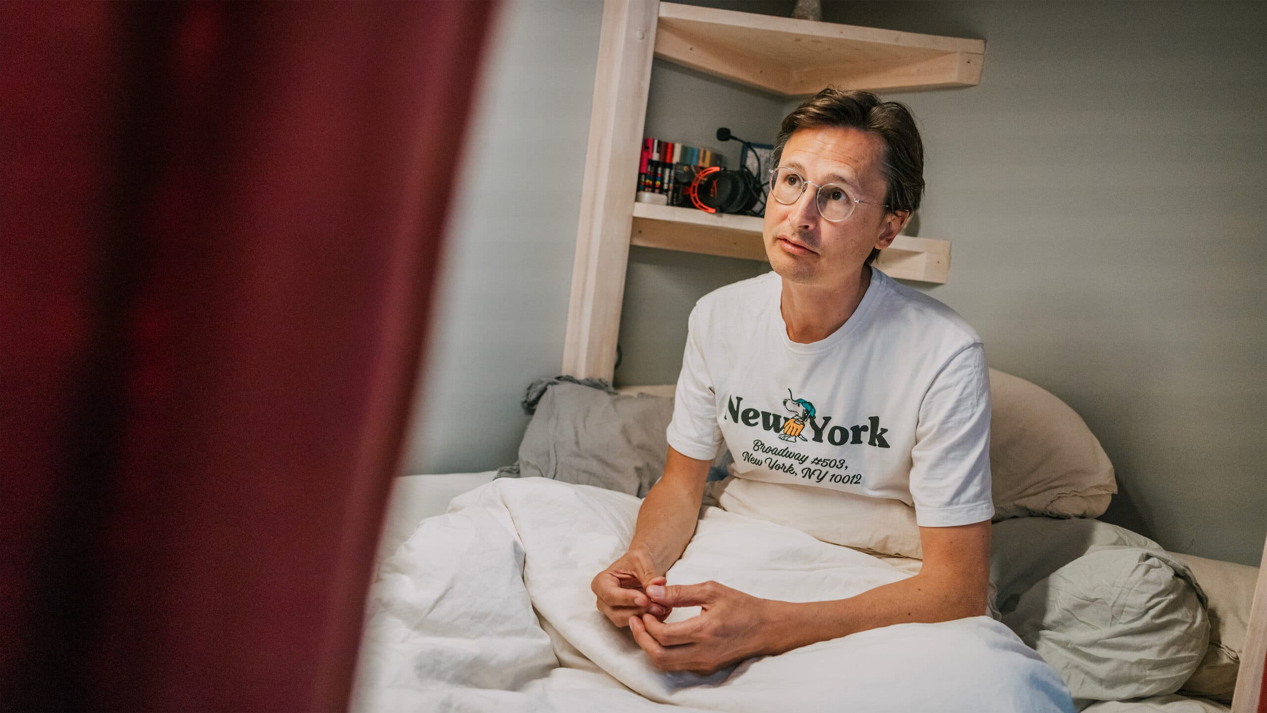 Niklas sitter upp i sängen i sonens rum.