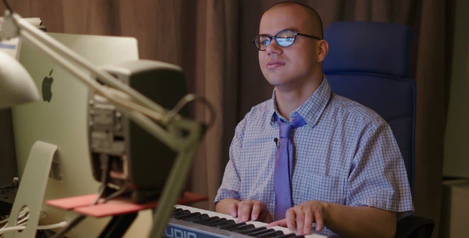 Alexander Forselius sitter framför en dator och spelar på ett digitalt keyboard.