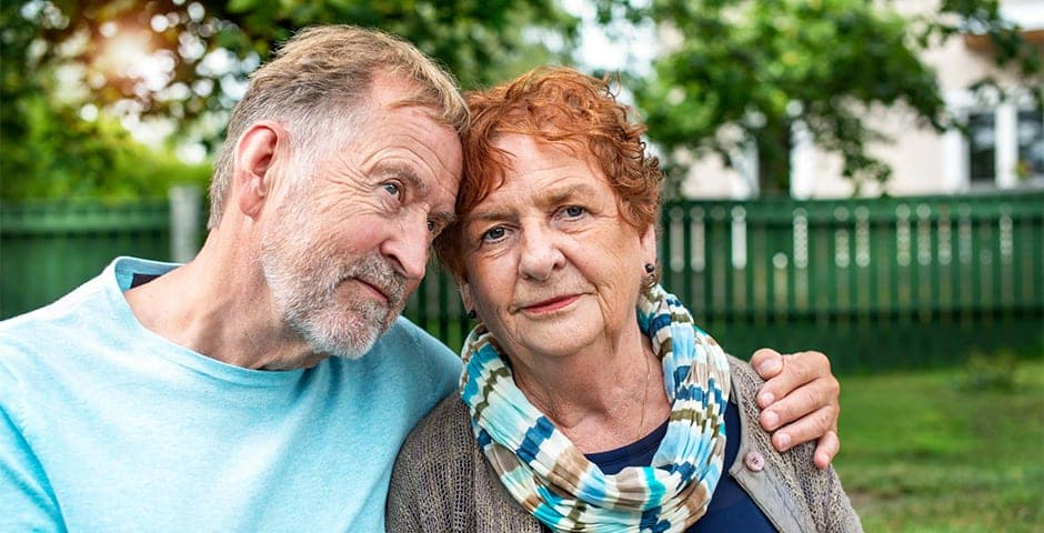 Man med Parkinsons sjukdom håller om sin fru