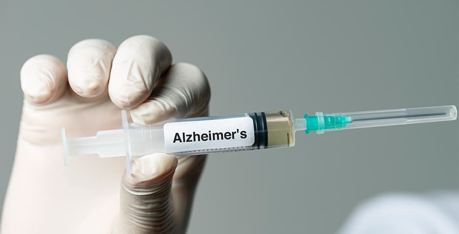 Doktor håller i en spruta med Alzheimermedicin