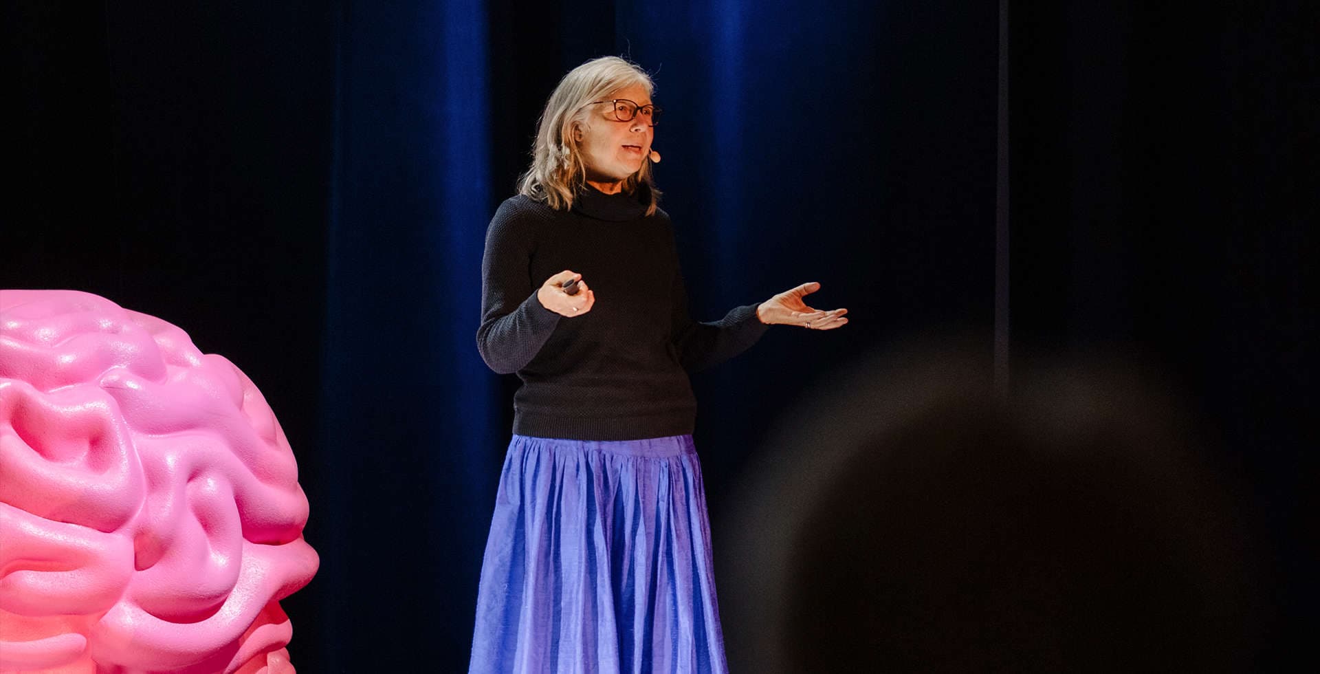 Birgitta Johansson står på en scen under Hjärnans Dag 2023 och föreläser hjärntrötthet.