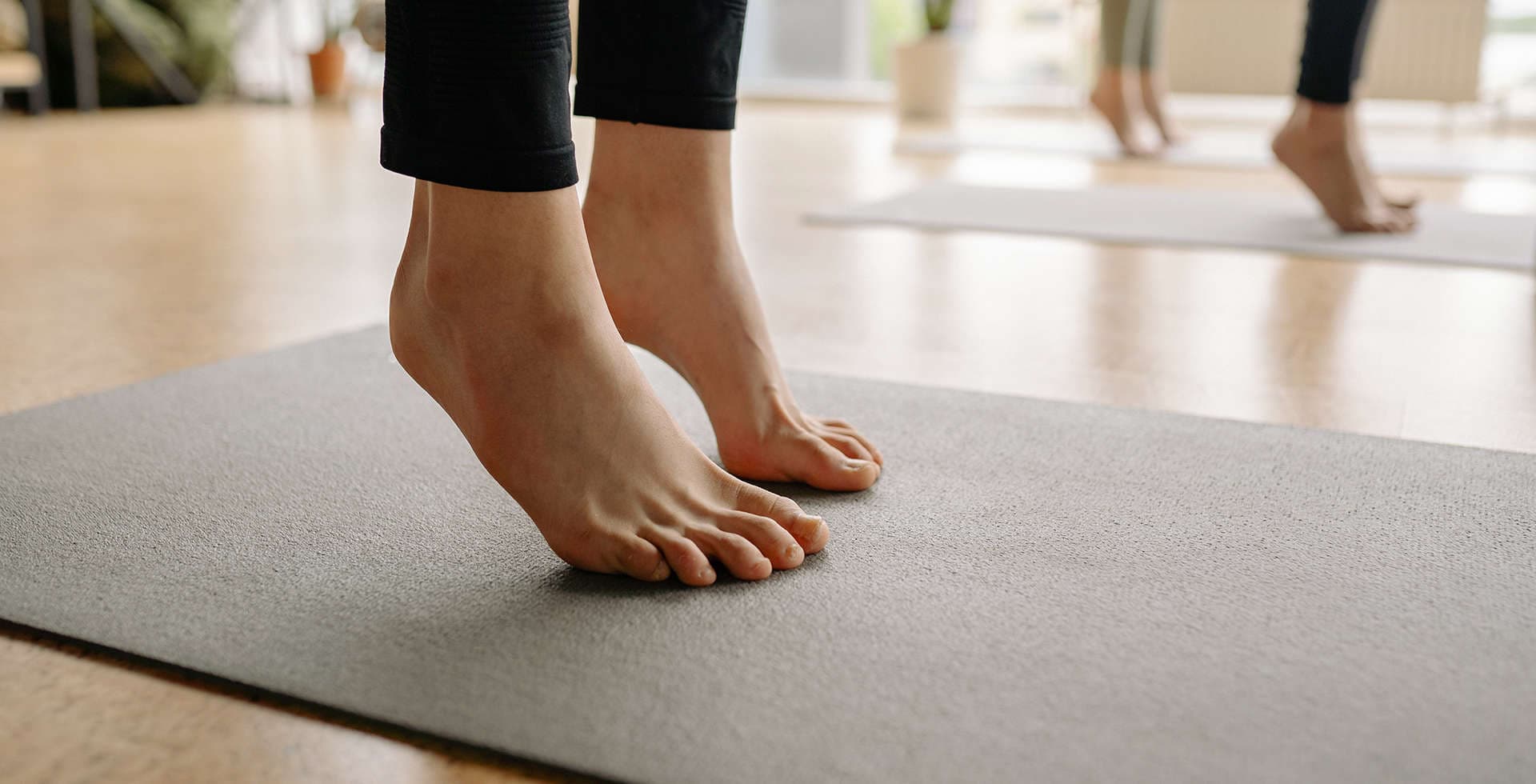 Närbild på fötter som utför yoga på en yogamatta