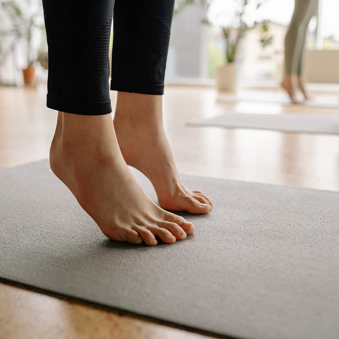 Närbild på fötter som utför yoga på en yogamatta