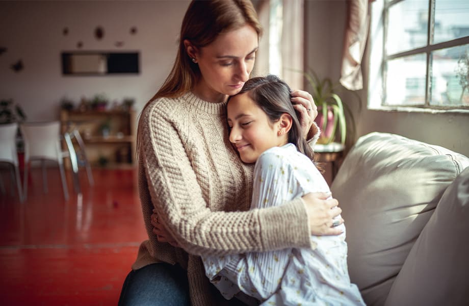 Mamma håller om sin dotter som är orolig för det nya Corona viruset