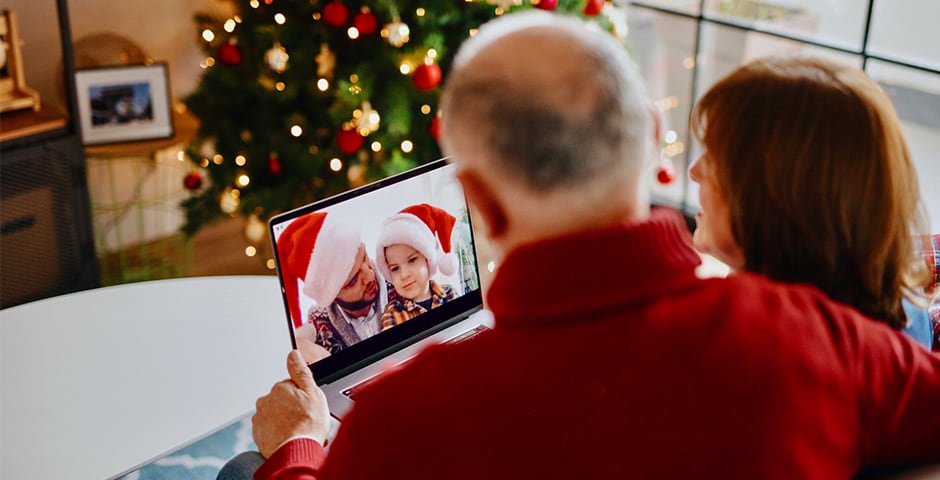 Äldre par talar med sitt barnbarn på datorn