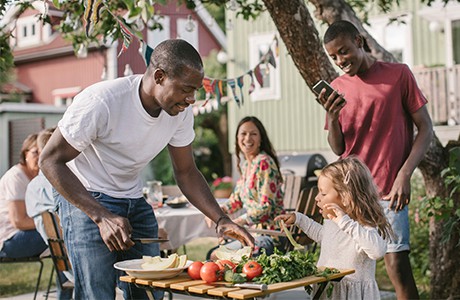 Familj äter i trädgården.