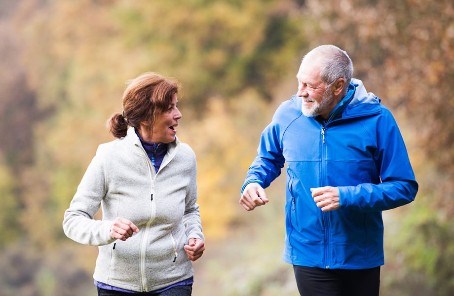 Medelålders man och kvinna joggar tillsammans.