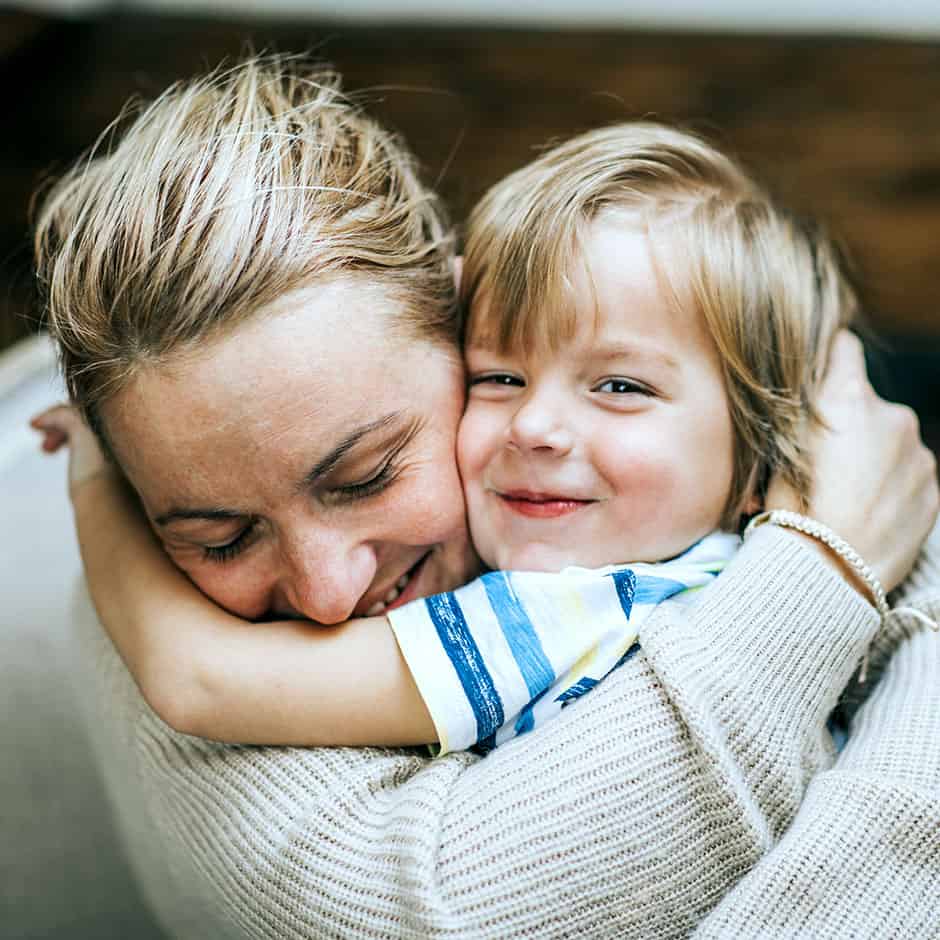 mamma som håller om sitt barn i famnen